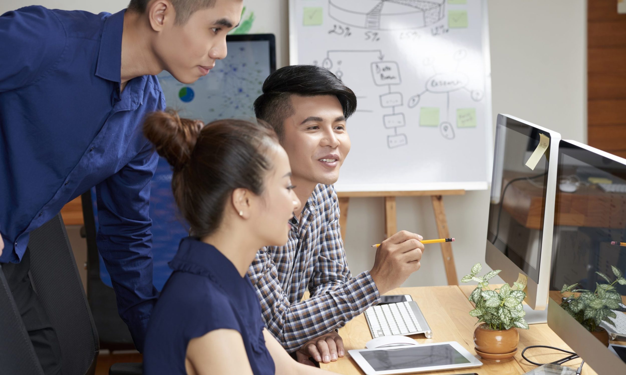 Positive Asian business team discussing possible ways of project development at meeting